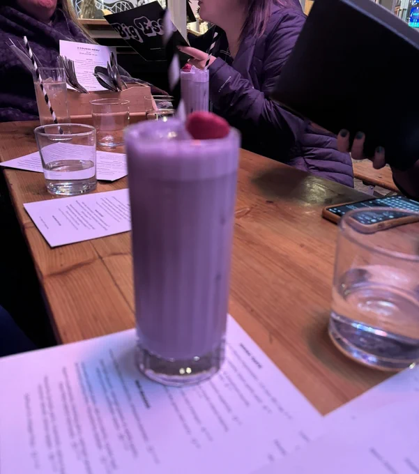 A purple drink, with a red fruit on top, and a straw sticking out of it. It is, also, unfortunately, out of focus. The one in the background is in perfect focus, but the one in the foreground... isn't. Oh well, better luck next time.

(And what does this purple drink have to do with any of this post? Well, that's what one of the Guests of Honour was drinking.)