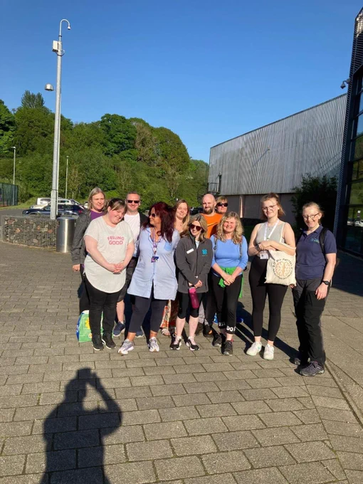 A group of people standing together smiling in the sun.