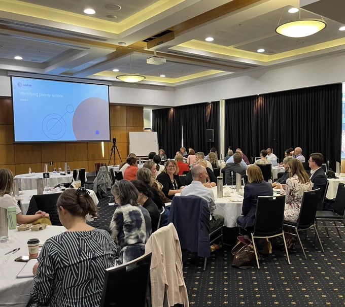 Participants at the national syphilis roundtable in discussion around large tables.