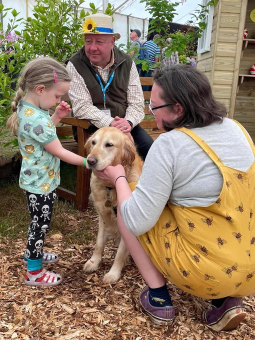 A young girl talking to Steve Darling and his Guide Dog Jenny