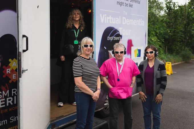 Staff standing in front of the virtual dementia bus.