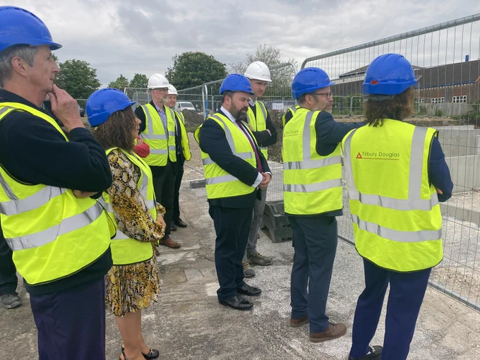 Group of people in hard hats view a construction site