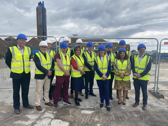 Group of people in hard hats in front of construction site