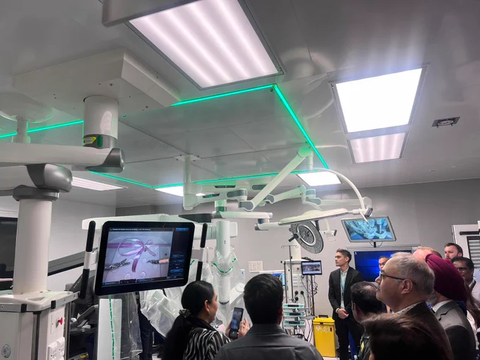 Guests watching Wes Streeting cut a ribbon with one of our surgical robots