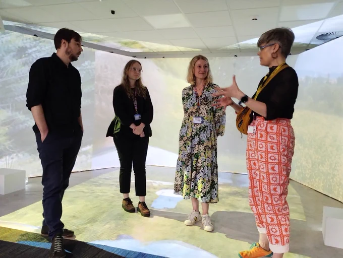Showing the immersive film experience about #communicationdifference 4 people talking to each other in the film space
