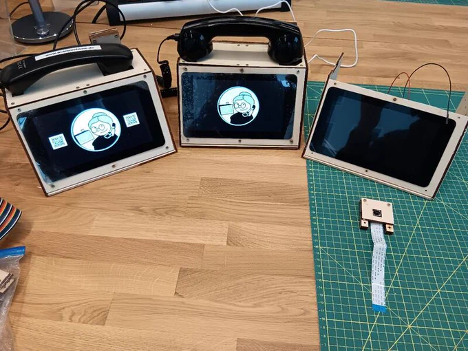Zwei eingeschaltete Grannophone-Prototypen, der dritte gerade noch im Zusammenbau rechts davon, auf einer Werkbank.