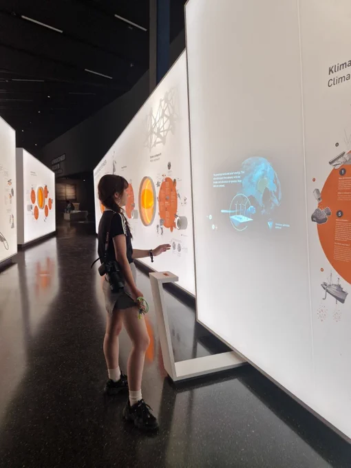 A student standing in front of a digital display on climate engineering making decisions on the digital display via hand gestures