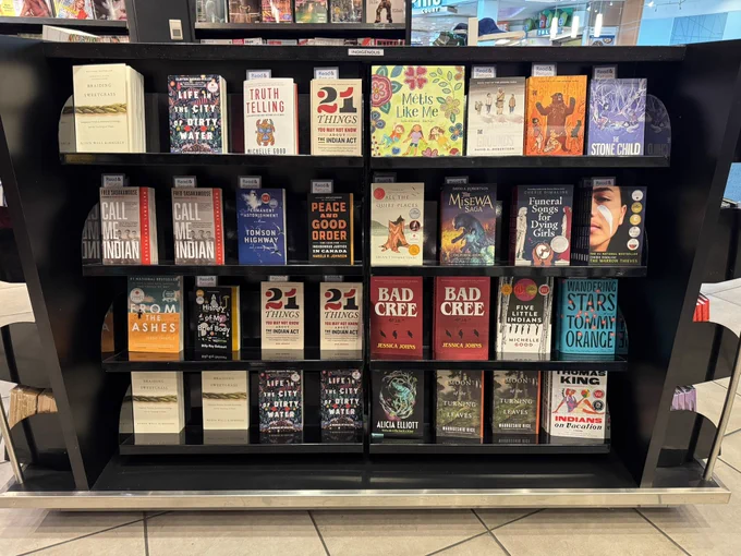 Four rows of books by Indigenous authors in display at a Vancouver Airport bookstore