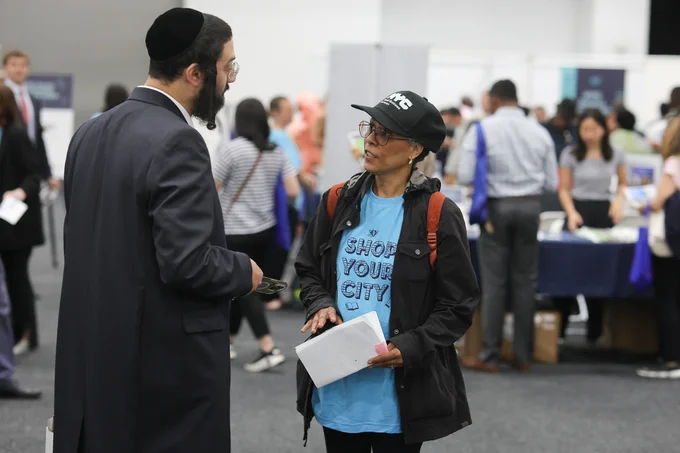 Man speaks with woman in blue shirt