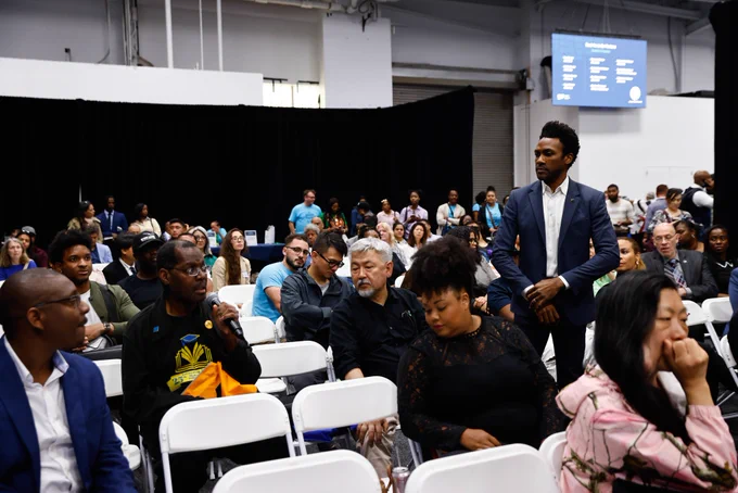 Man holds microphone in seated crowd