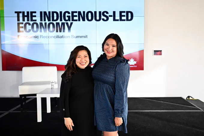 The Honourable Mary Ng, left, and Tiara Folkes, right, standing and smiling. 