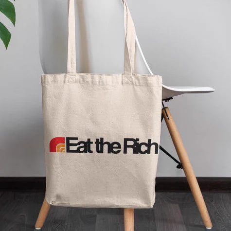 A tote bag that says eat the rich, and the text is meant to look like the loblaw logo