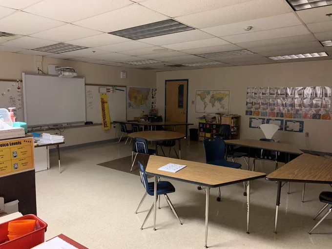 A photo of an empty school classroom with the lights dimmed. 