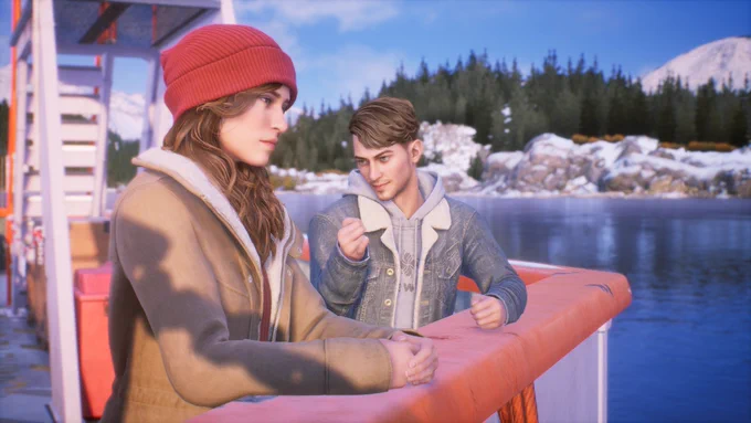 A young man in a denim jacket holds out his pinky finger to a young woman in a red beanie and tan coat, as if making a promise. They are on a boat, and in the background is beautiful Alaskan scenery with a peek at a mountain.
