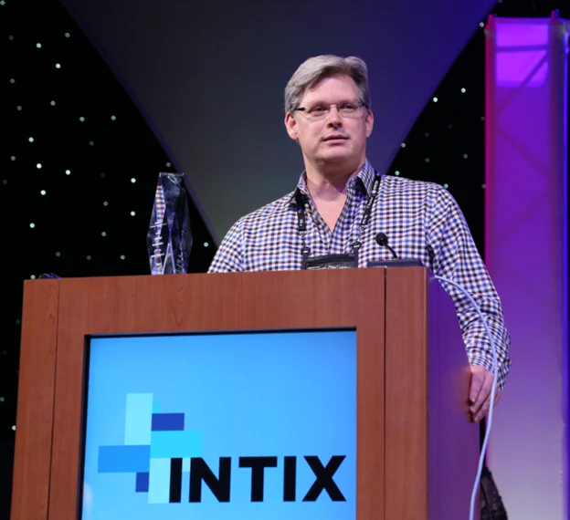 Photo of Joe Carter standing behind a podium at an INTIX conference.