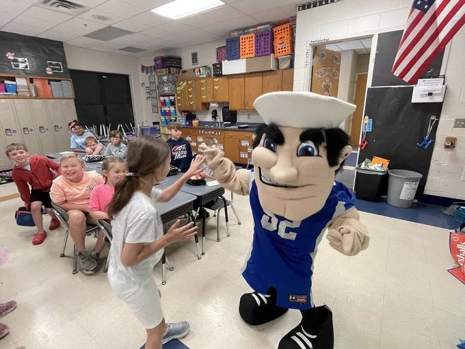 Students high fiving a Middie Man Costume