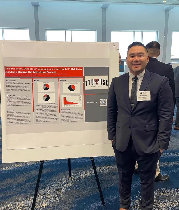 Male TTUHSC emergency medicine resident stands next to his poster.