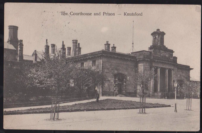 The front face of an Edwardian postcard. A black a s white photo of the front of Knutsford Courthouse and Prison.