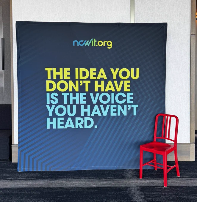 A banner that reads: The idea you don’t have is the voice you haven’t heard. A red chair in front
