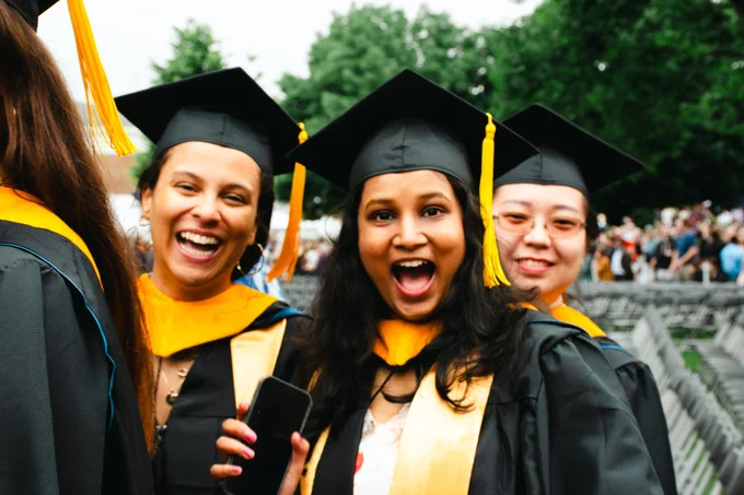Three Data Science students wave and smile at the camera.
