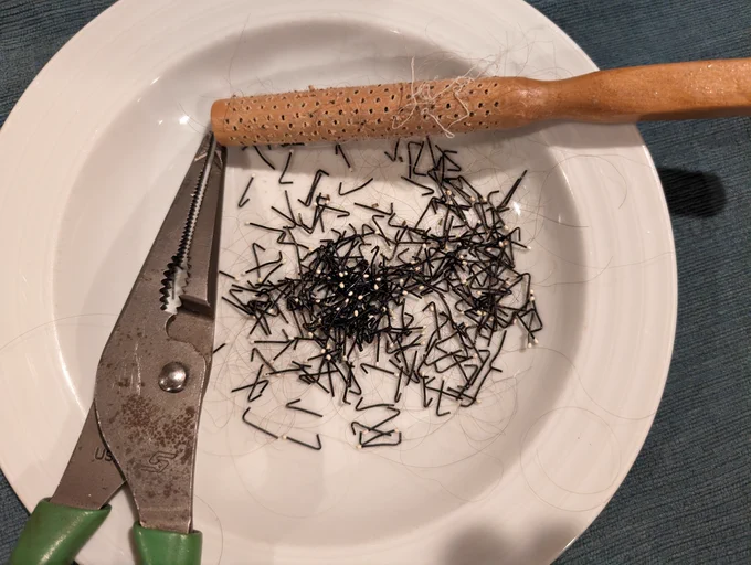 pliers and a disassembled hair brush