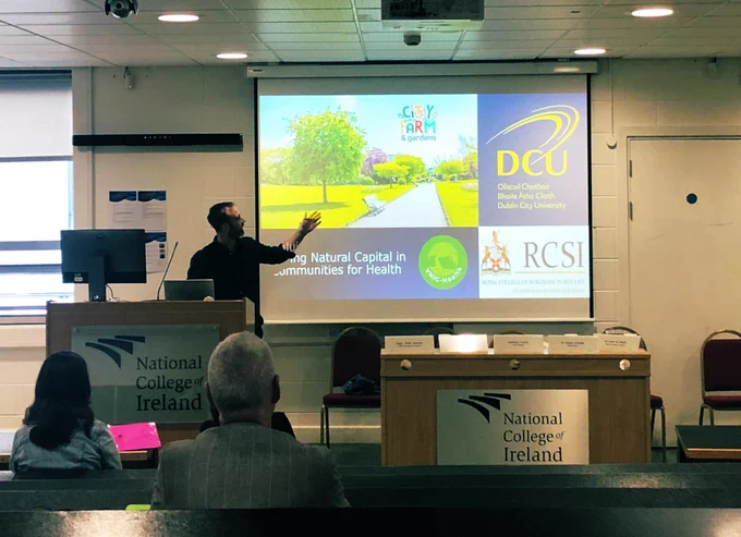 Man points at screen with slide with logos and photo of park