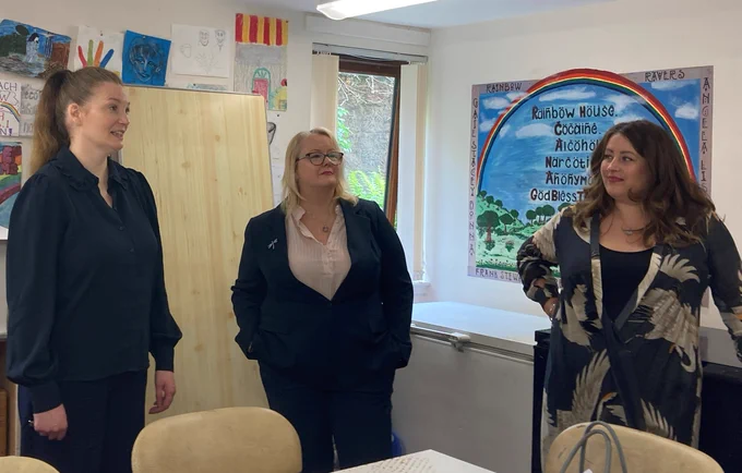 Drugs and Alcohol Policy Minister Christina McKelvie in the arts room at Crossreach's Residential Recovery Service in Glasgow with blue poster listing types of drugs on wall and CrossReach Service Manager Catriona McCabe and Corra Programme Lead Rowan Anderson