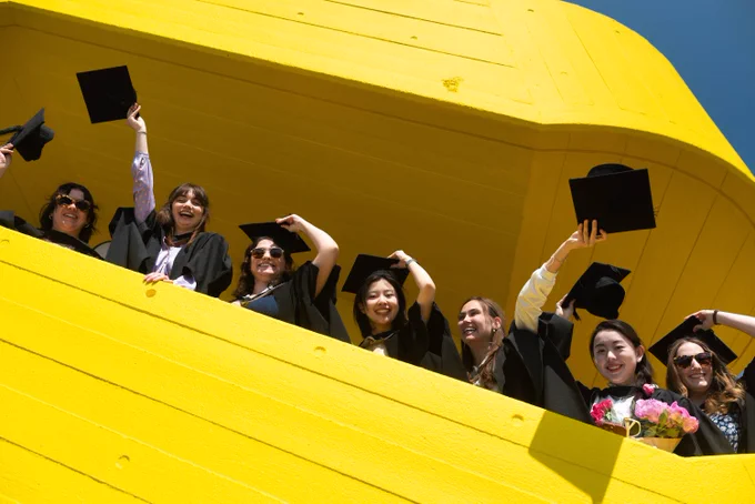 Graduates on yellow stairs