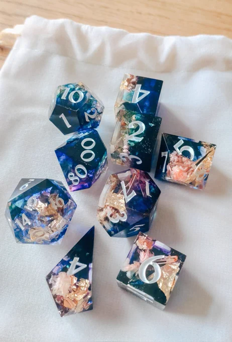 A 9 piece ttrpg dice set with gold foil