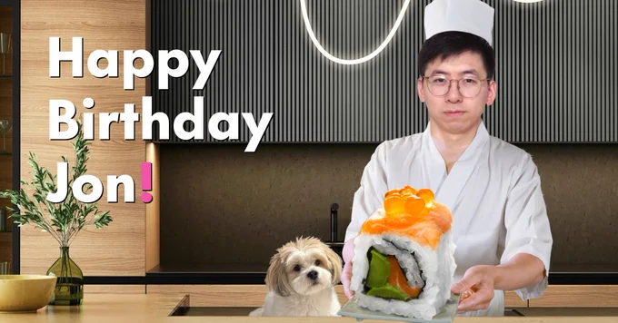 Jon is dressed as a chef in a modern kitchen, holding a plate with a giant sushi roll on it that he made. His dog, Mochi, sits impatiently beside him, staring at the sushi.