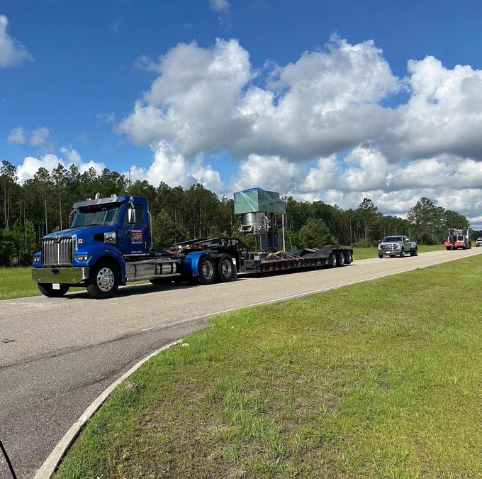 Semi trailer pulling Evolution Space’s 200 gallon propellant mixer with multiple trucks following.