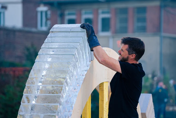 ARCH is a performance that happens outdoors and shows 2 people building a freestanding arch made with concrete and ice, with sounds of a choir singing from where the audience sits. At the end the arch might fall down or stay up. 
