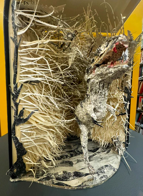paper sculpture of a dinosaur made from pages and cover of a book