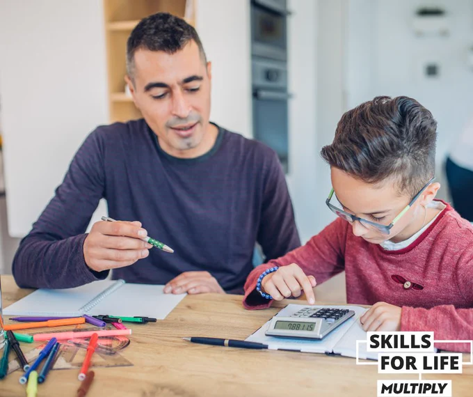 Dad doing maths homework with son