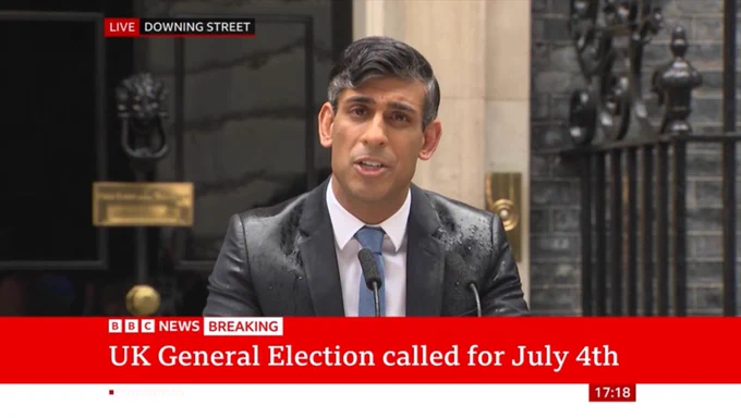Rishi Sunak with wet shoulders wearing a suit