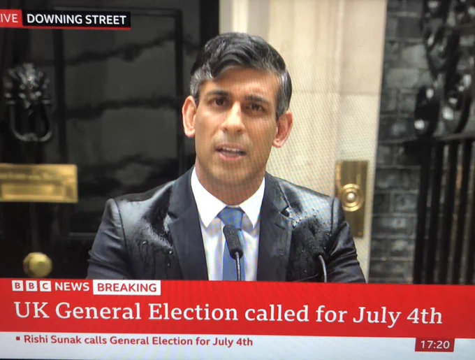Image of Rishi Sunak with water soaking the shoulders of his suit as he announces the election outside number ten in the rain.