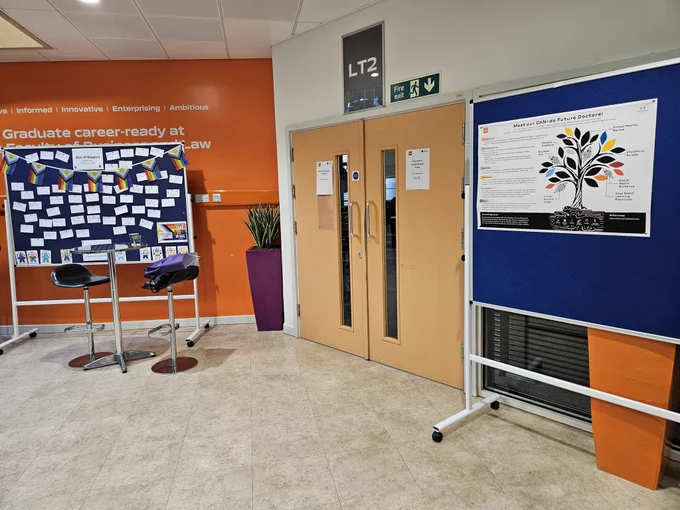 Poster boards by lecture theatre doors.
