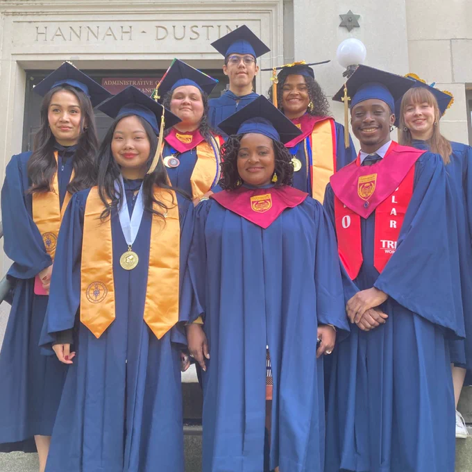 Graduates pose in cap and gown