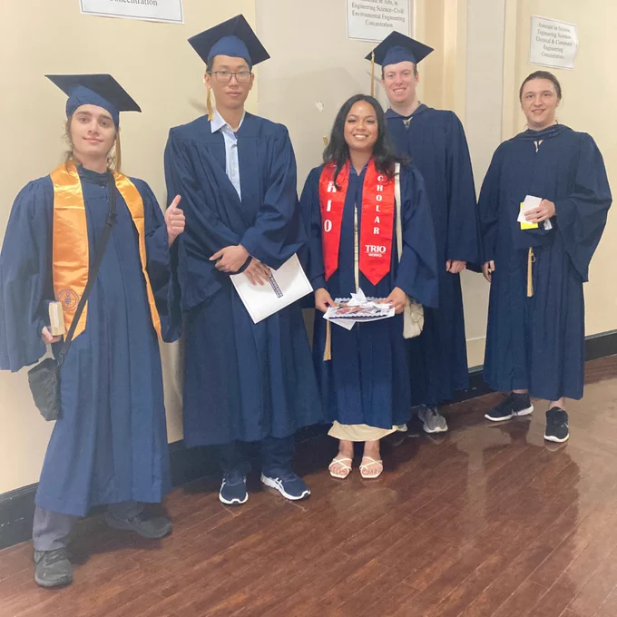 Graduates pose in cap and gown