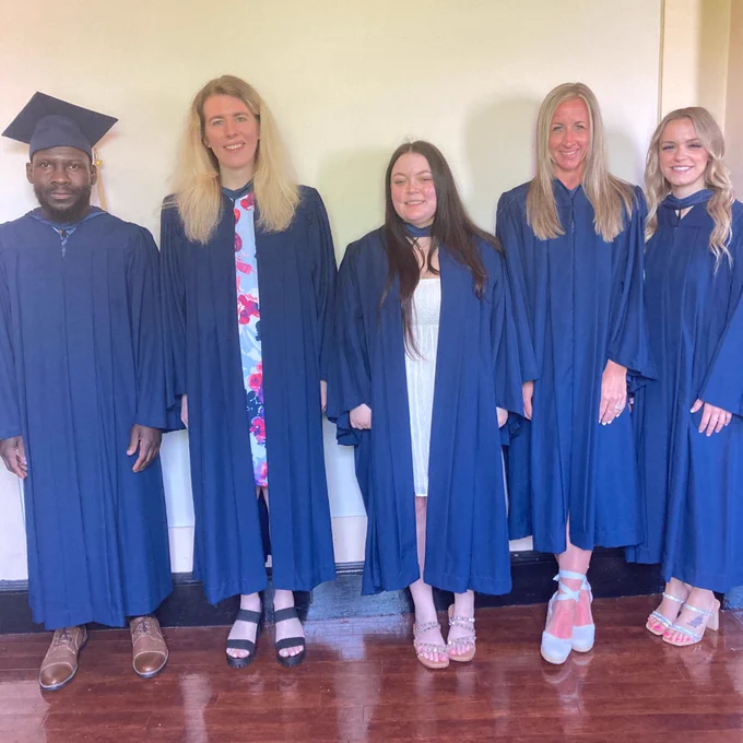 Graduates pose in cap and gown