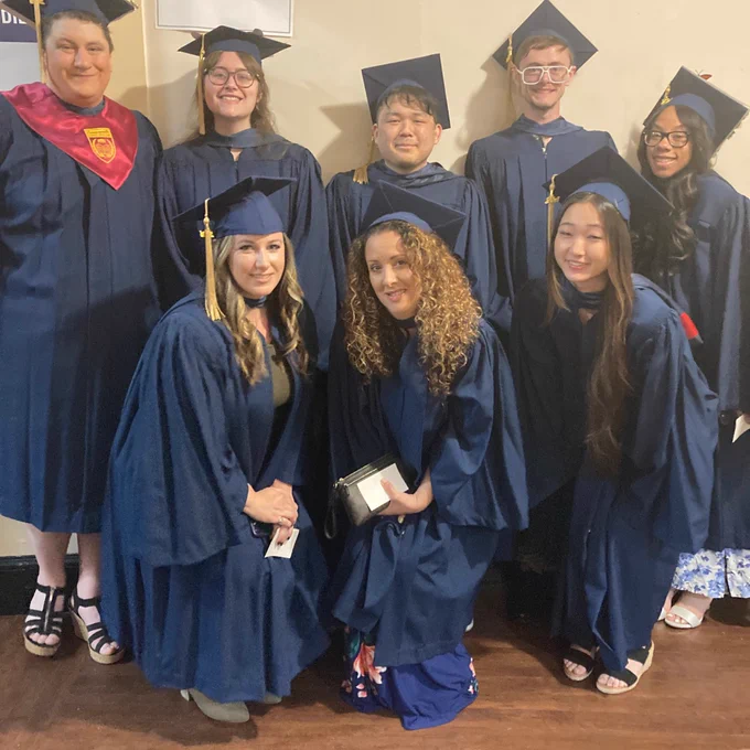 Graduates pose in cap and gown