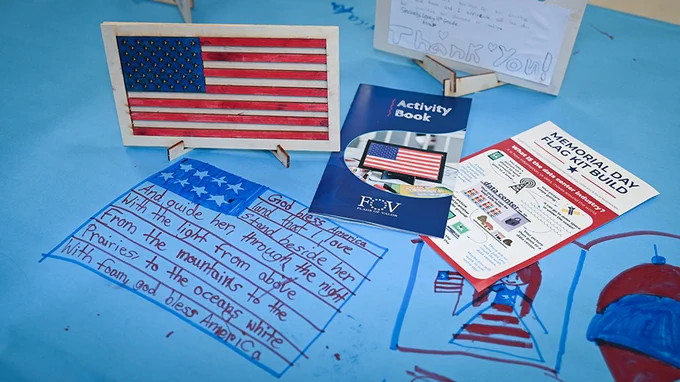 Student made American flag with drawings and messages written on a blue table