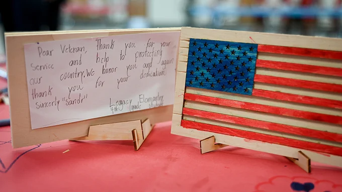 Wooden American flag with a student's written message next to it