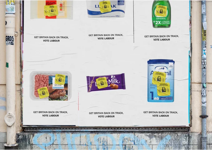 Image of various supermarket items (e.g. cheese, butter, washing up liquid) with a yellow supermarket security tag - text below reads "Get Britain back on track, vote labour"