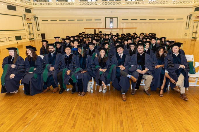 School of Medicine Class of 2024 graduates wearing their regalia, waiting in the ballroom of Soldiers and Sailors Memorial Hall for the commencement ceremony to begin.
