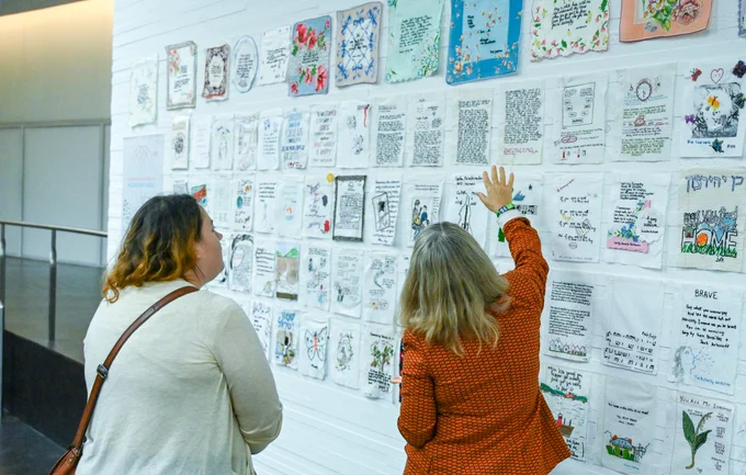 Diana showing someone the different embroidered projects