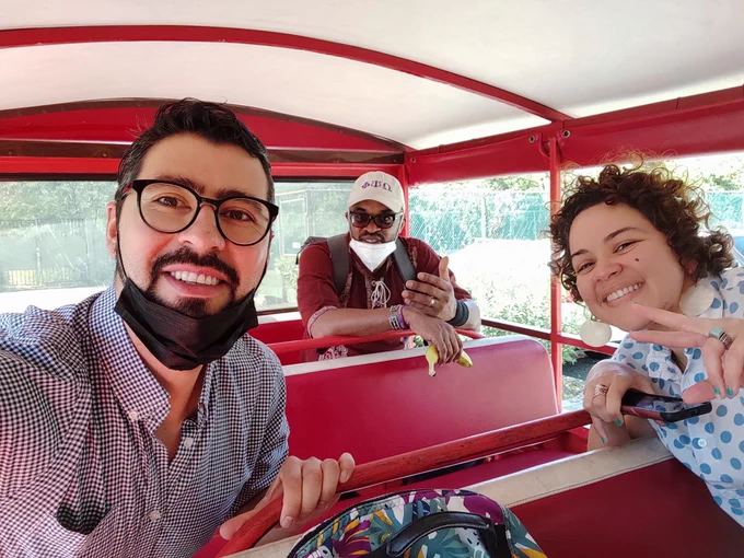 A selfie of Manuel and two other people riding in a covered bus.