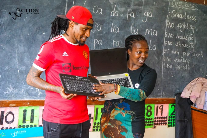 Stacy Irara, STEM Lead and Kevin Kimani, Workshop Technician, holding 2 keyboards explaining the differences between them
