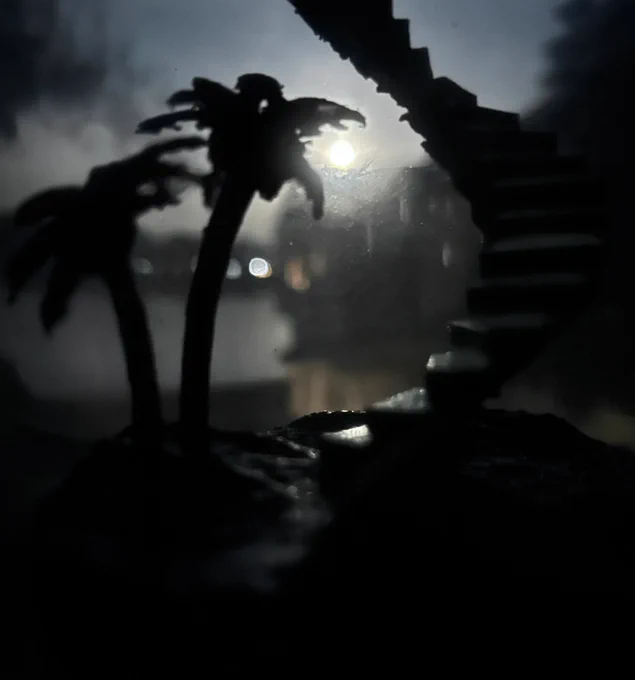 A photograph of a 3D print based off of Hawaii: Part II by Miracle Musical, with the full moon shining over water visible in the background