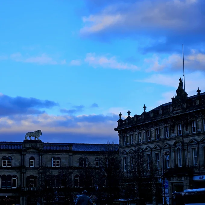 The view from St George's Square Huddersfield of a lion and a man sculpture atop old buildings